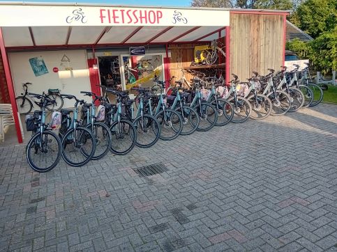 Een lange rij huurfietsen en e-bikes voor de winkel van Fietsshop Heuvelland in Banholt